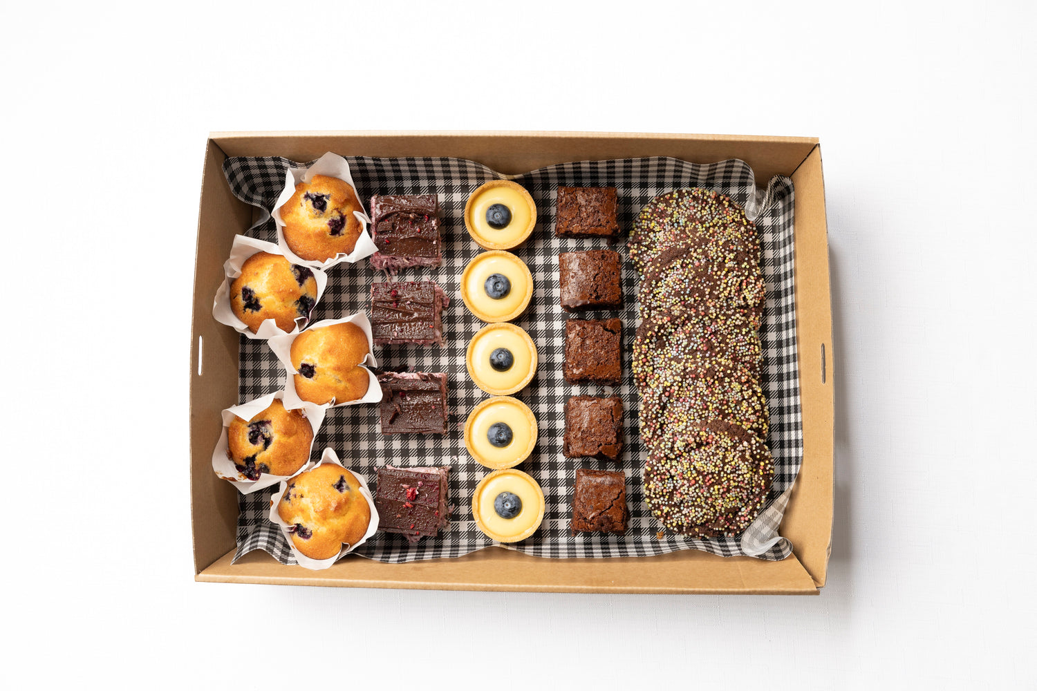 A box of Chocolate Brownie, Lemon Curd Tarts with Blueberry, Raspberry Ripe Slice, Chocolate Sprinkle Biscuits, & Blueberry Mini Muffins